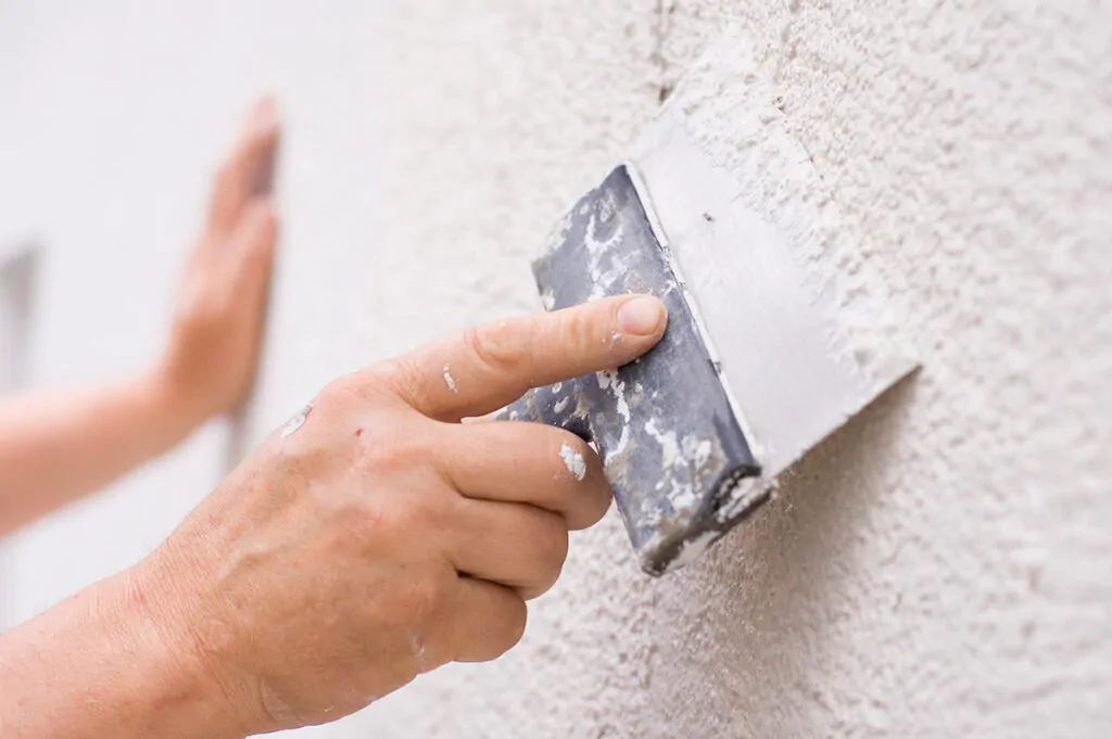 a picture of a man painting plaster