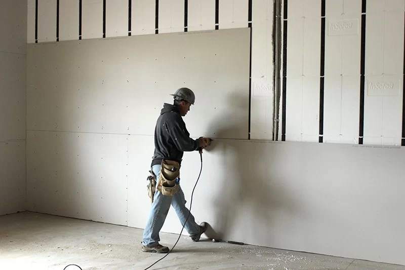 a man hanging dry wall