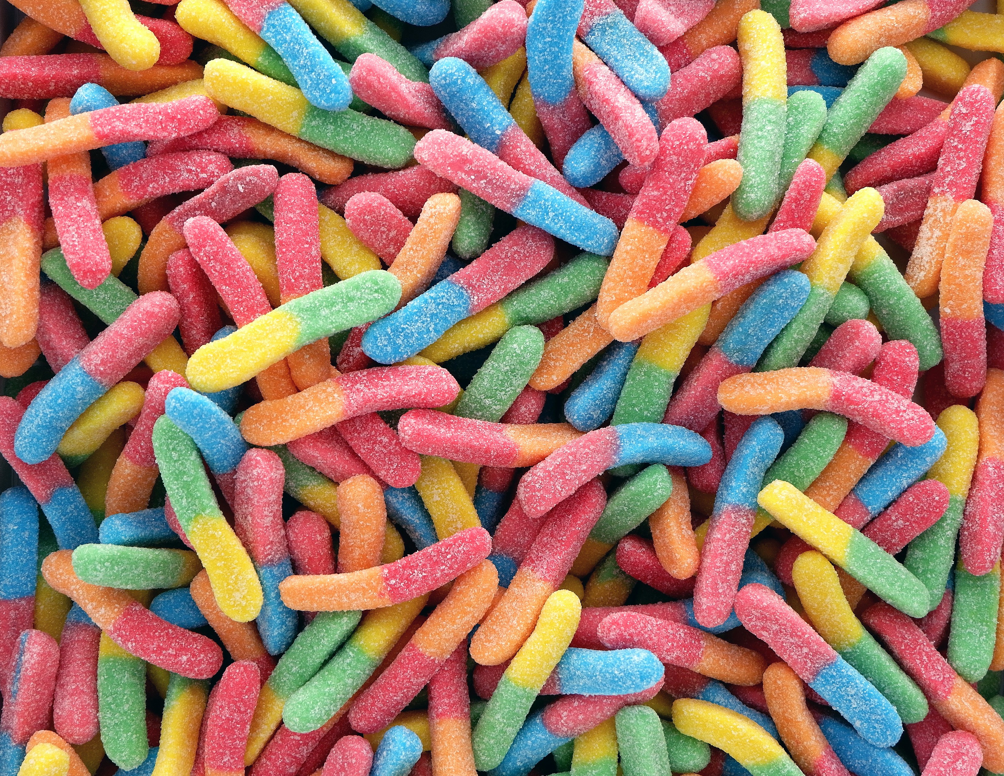 Colorful sour gummy worms sprinkled with sugar
